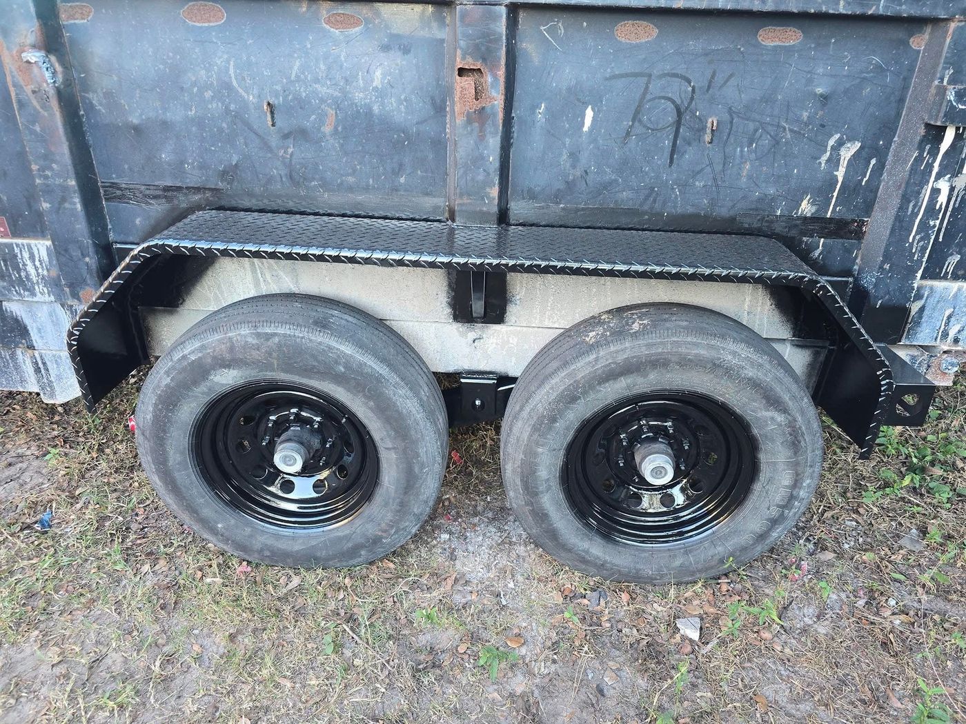 Dump trailer with new diamond-plate fender and refinished black wheels
