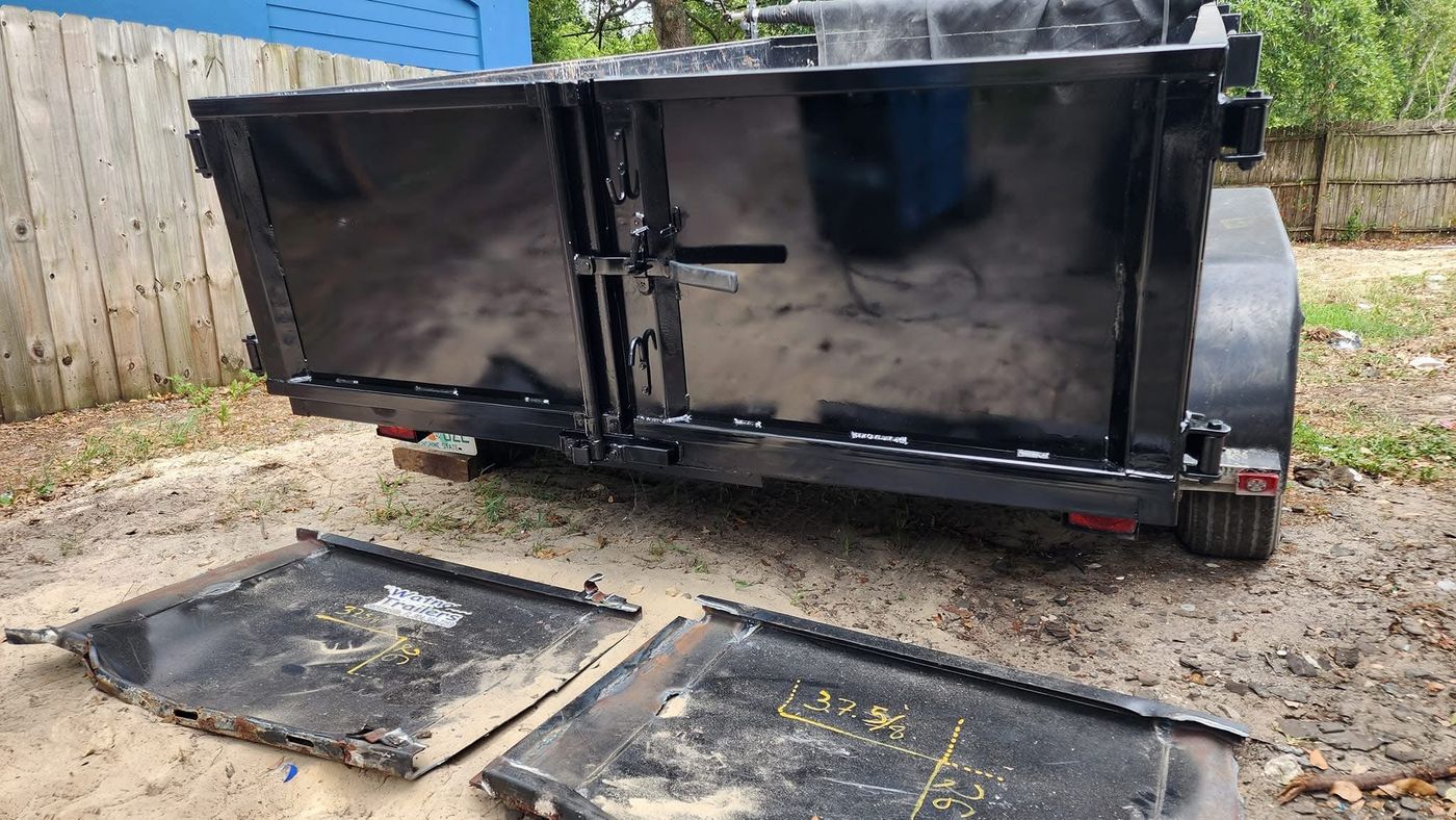 Dump trailer with repaired and repainted rear gate