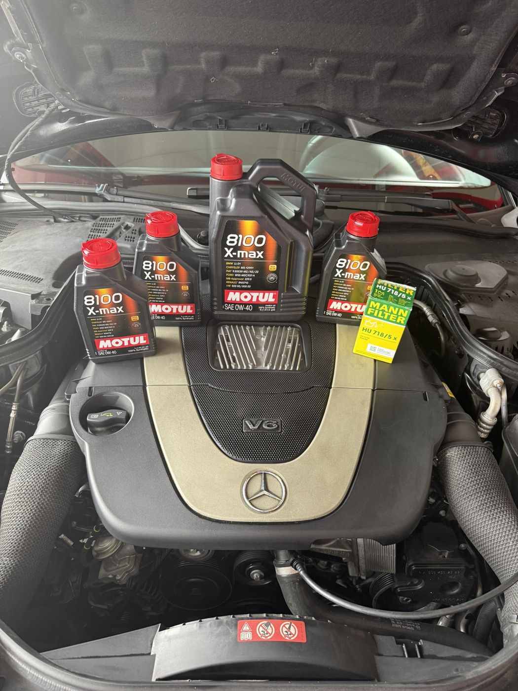 Synthetic oil and filter staged on an engine before an oil change