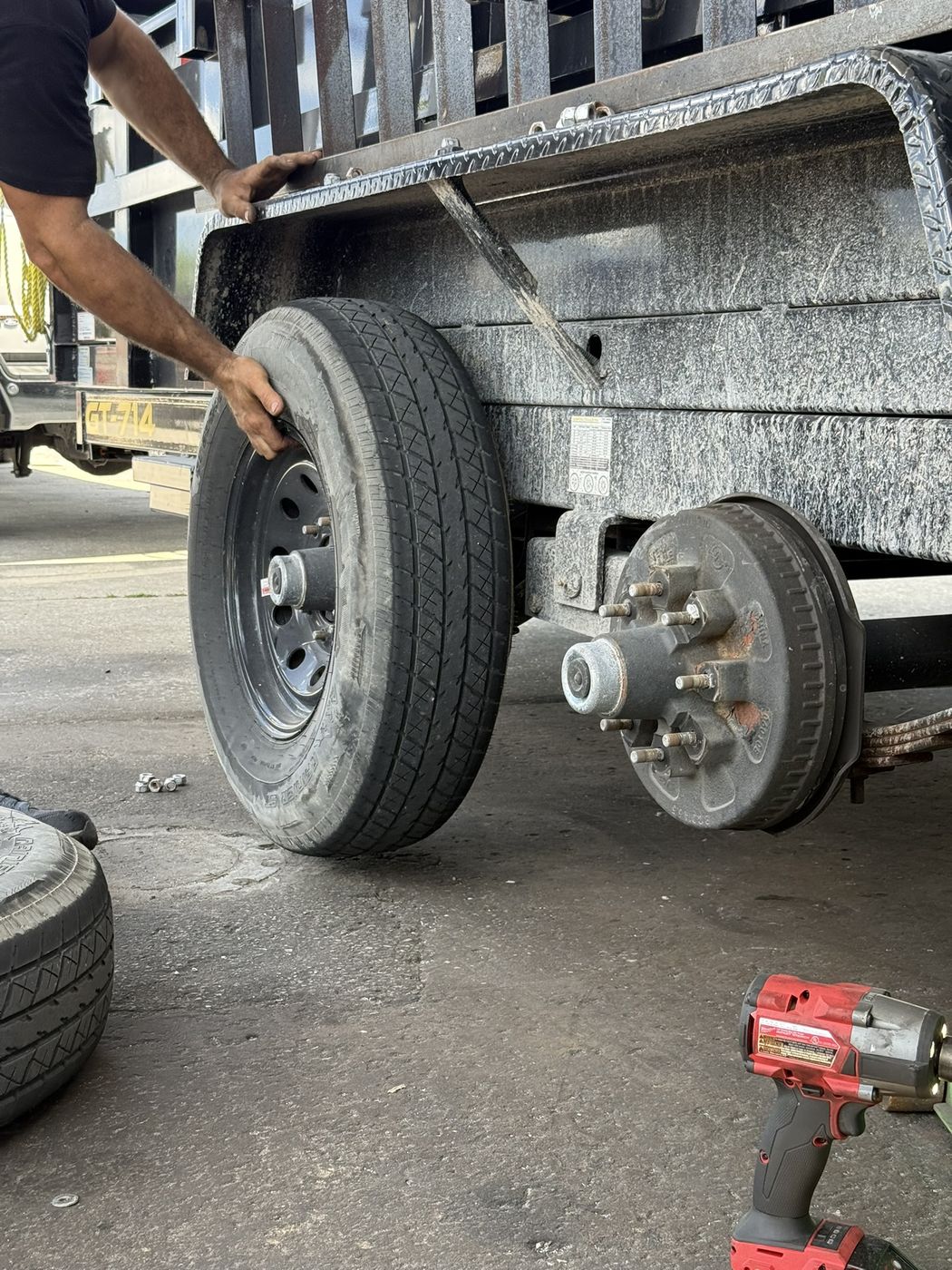 Mechanic removing a trailer tire to service the brake drum